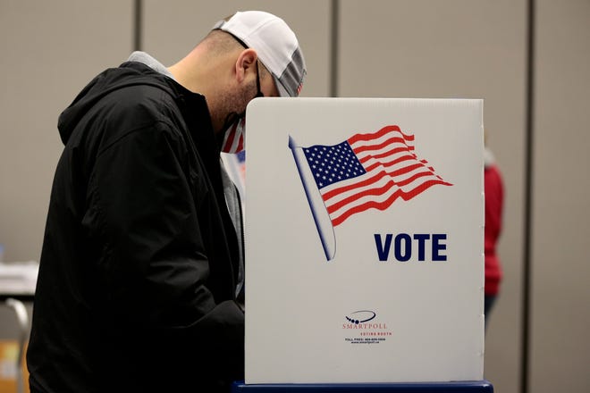 Voters fill out early ballots at the Boone County Extension Enrichment Center in Burlington, Ky., on Tuesday, Oct. 13, 2020.