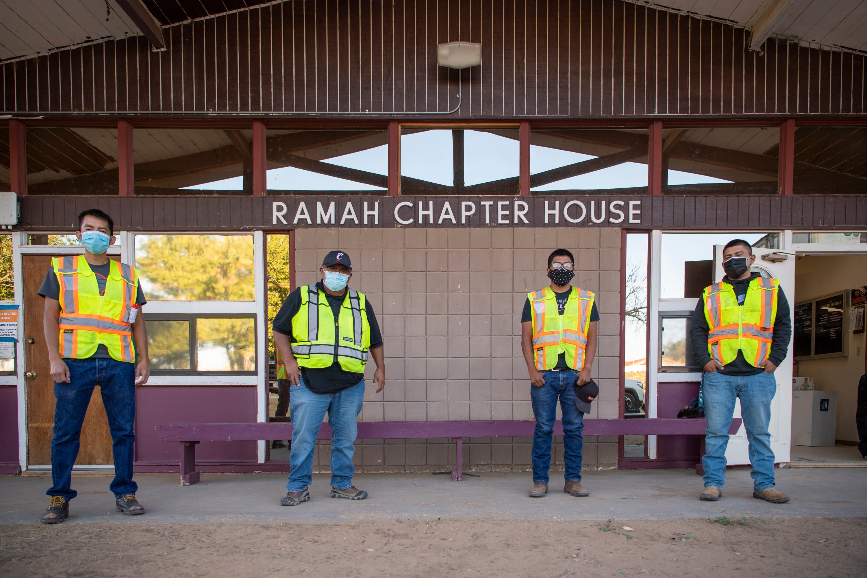 Derek Henio, Randy Chatto, Vernard Martinez and Jimmie Begay, from left, pose for a photo in front of the Ramah Chapter House, where they stage deliveries of supplies to at-risk residents on the Ramah Navajo Indian Reservation.
