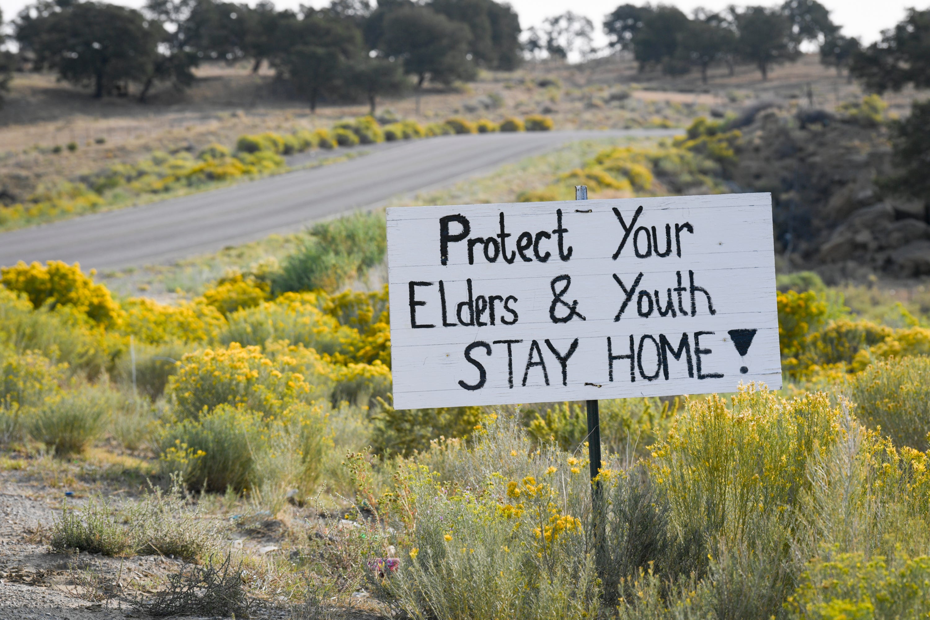 A sign on the Navajo Nation Indian Reservation in Smith Lake, N.M., warns people to protect their families during the coronavirus pandemic.