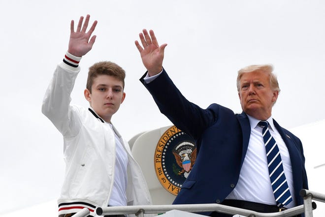 In this Aug. 16, 2020, file photo, President Donald Trump, right, and his son Barron Trump wave from the top of the steps to Air Force One at Morristown Municipal Airport in Morristown, N.J.