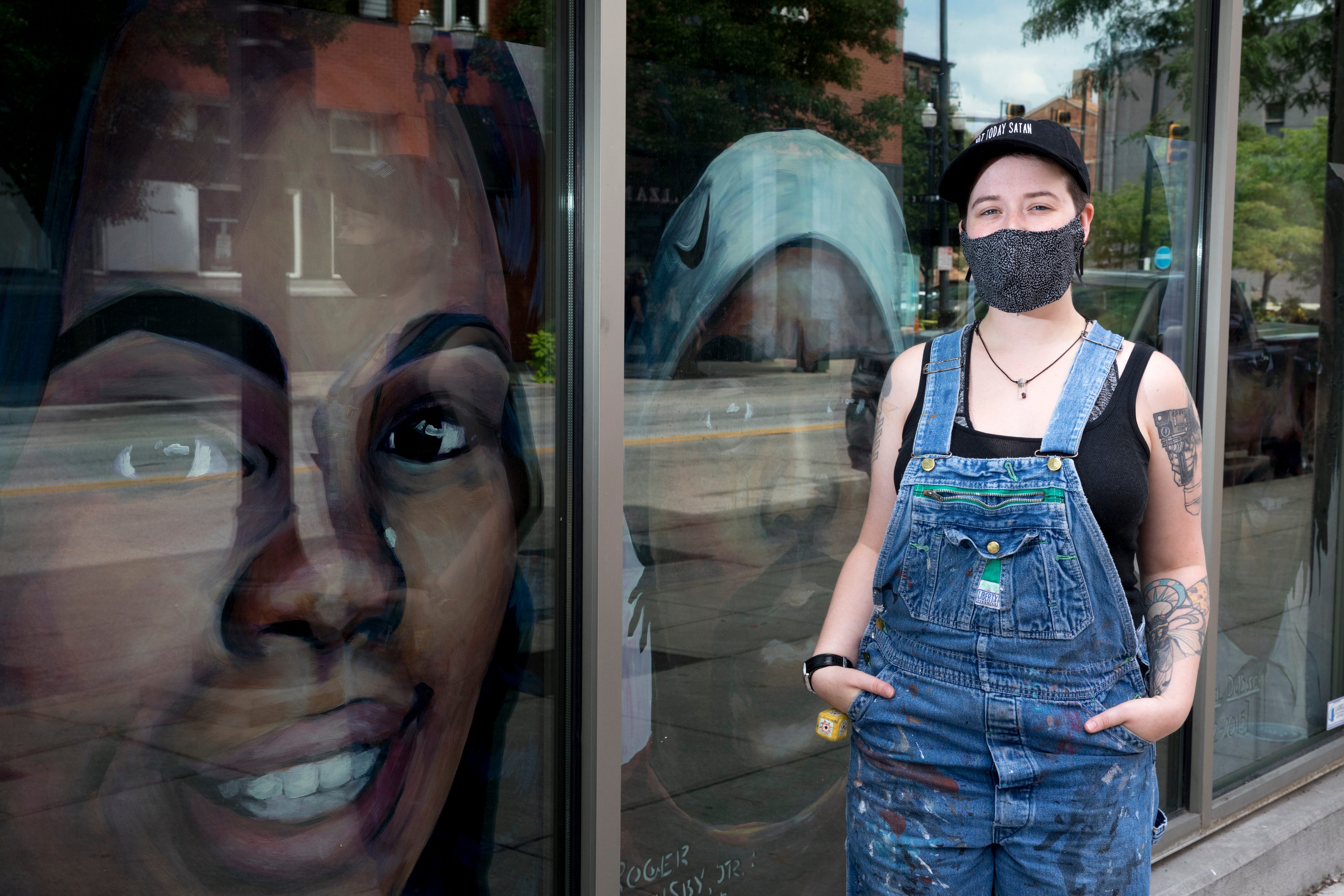 Rae Kuhn stands outside Ensemble Theatre Cincinnati, where she works as a scenic artist, in Over-The-Rhine on Aug. 4. "I'm extremely lucky that my place of business was open to me producing portraits of some of the victims of police police brutality," Kuhn said. Kuhn's donated portraits of Timothy Thomas, Samuel DuBose, Breonna Taylor and Roger Owensby Jr., all of whom died at the hands of police.