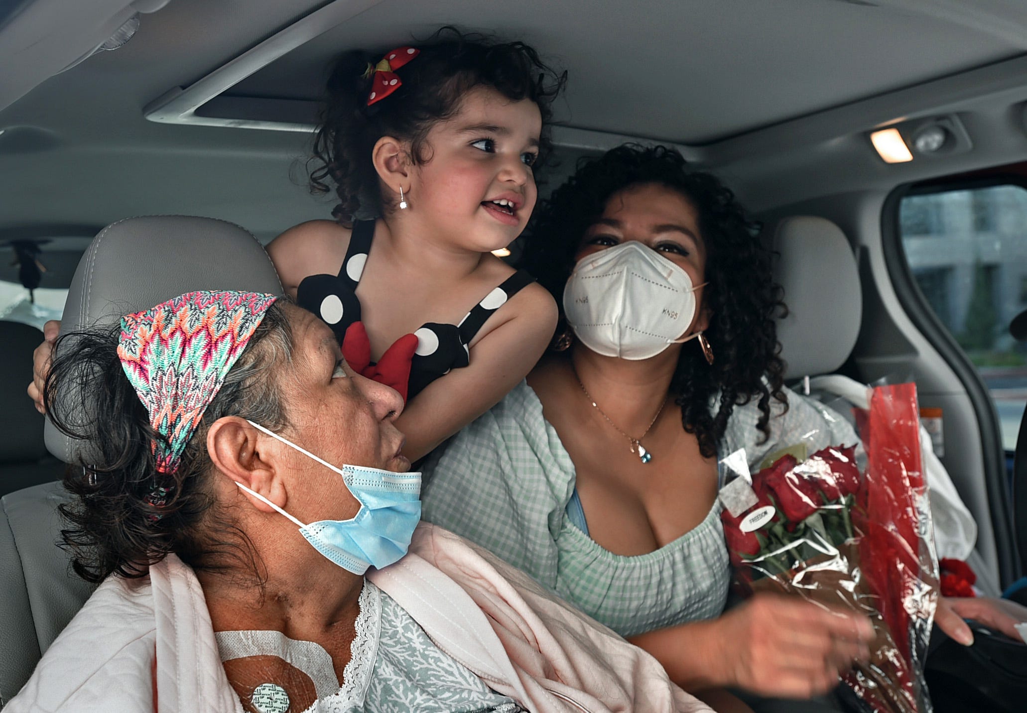 Patricia Villaseca sits in the family car with granddaughter Gadi Camacho, 4, and daughter Cyndi Camacho after being discharged from Saint Mary's Regional Medical Center where she was hospitalized 5 months after contracting COVID-19 in April 2020. Villaseca, 60, survived COVID-19 despite having an underlying condition. Her daughter Cyndi Camacho, right, also contracted COVID-19 while being pregnant.