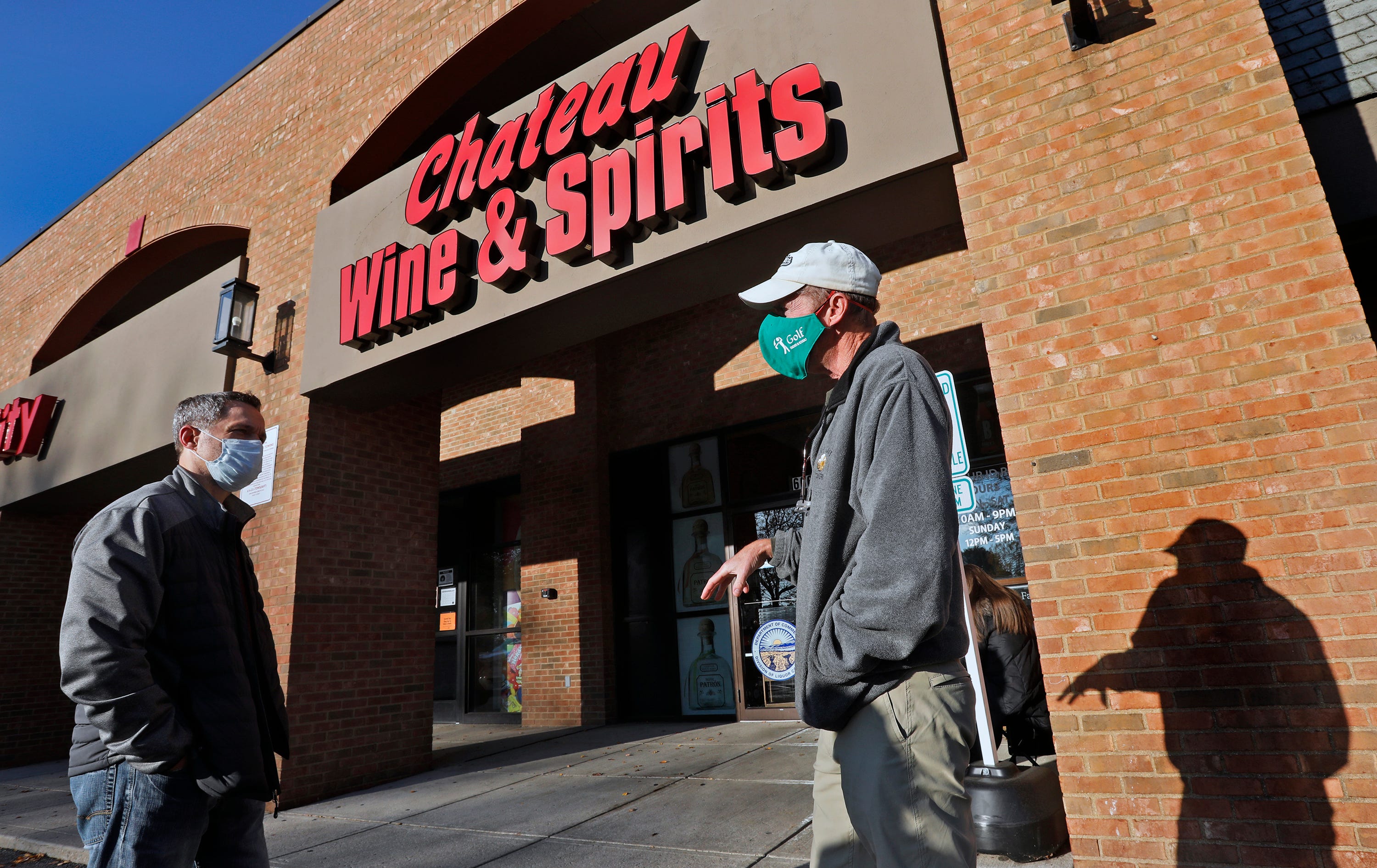Kirk Seman, left, talks to Mike Baker while they wait for the doors to open at Chateu Wine & Spirits in Dublin.