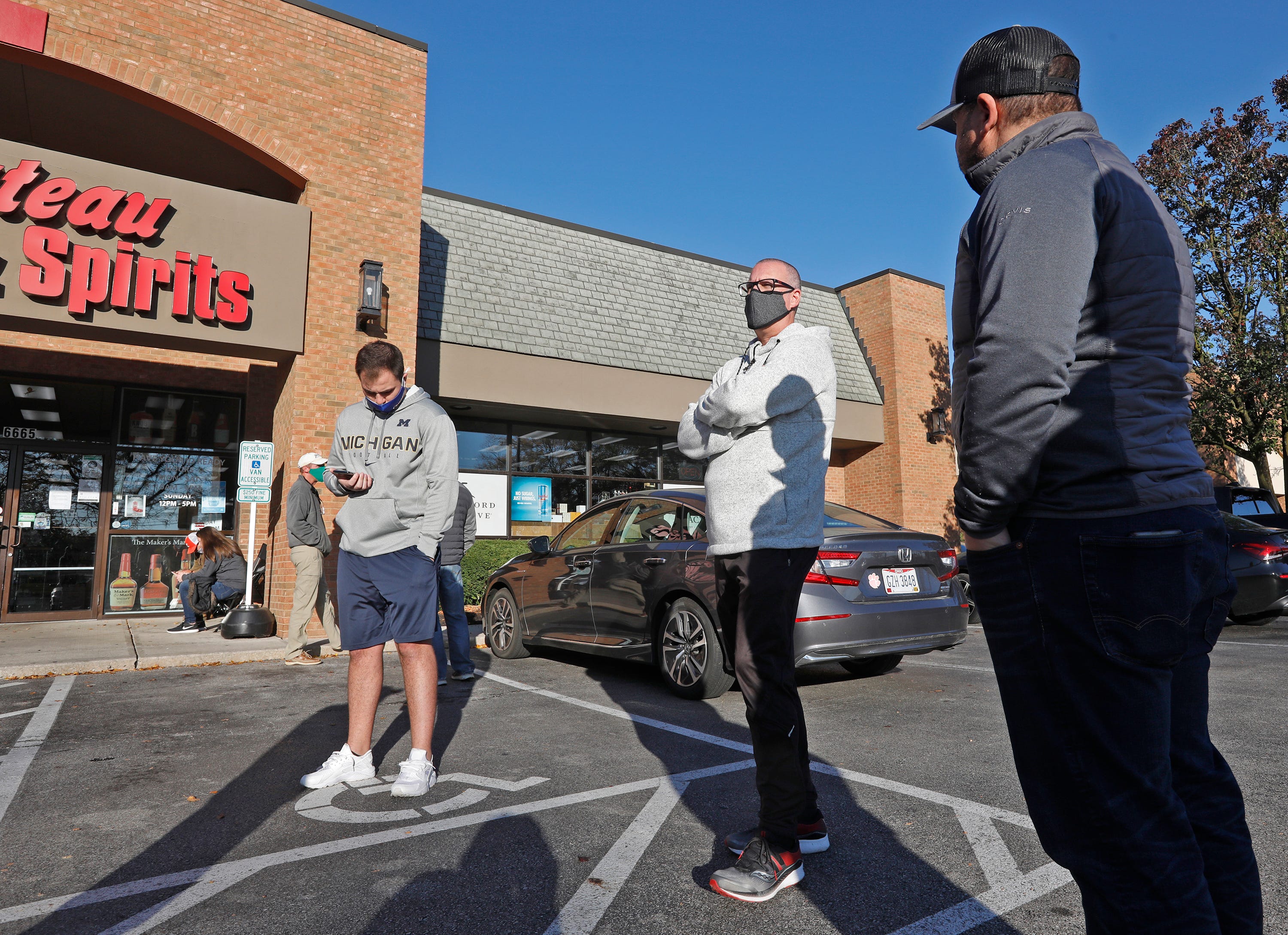 Jason Callori, right, of Dublin, and friend Scott Page of Milwaukee were among more than a dozen people waiting for Chateau Wine & Spirits to open in Dublin recently.