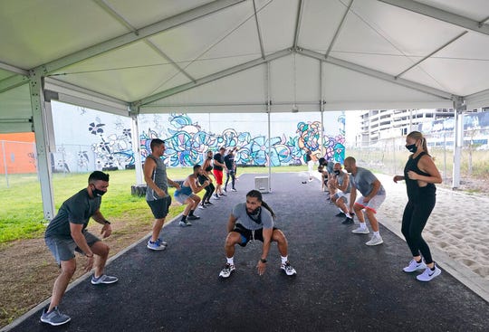 Trainer Legend Tarvers, center, leads a group during a workout at Legacy Fit, Monday, Aug. 31, 2020, in Miami. As the vast majority of in-person fitness clubs switched to virtual classes when the pandemic hit, Legacy Fit took the opposite approach.
