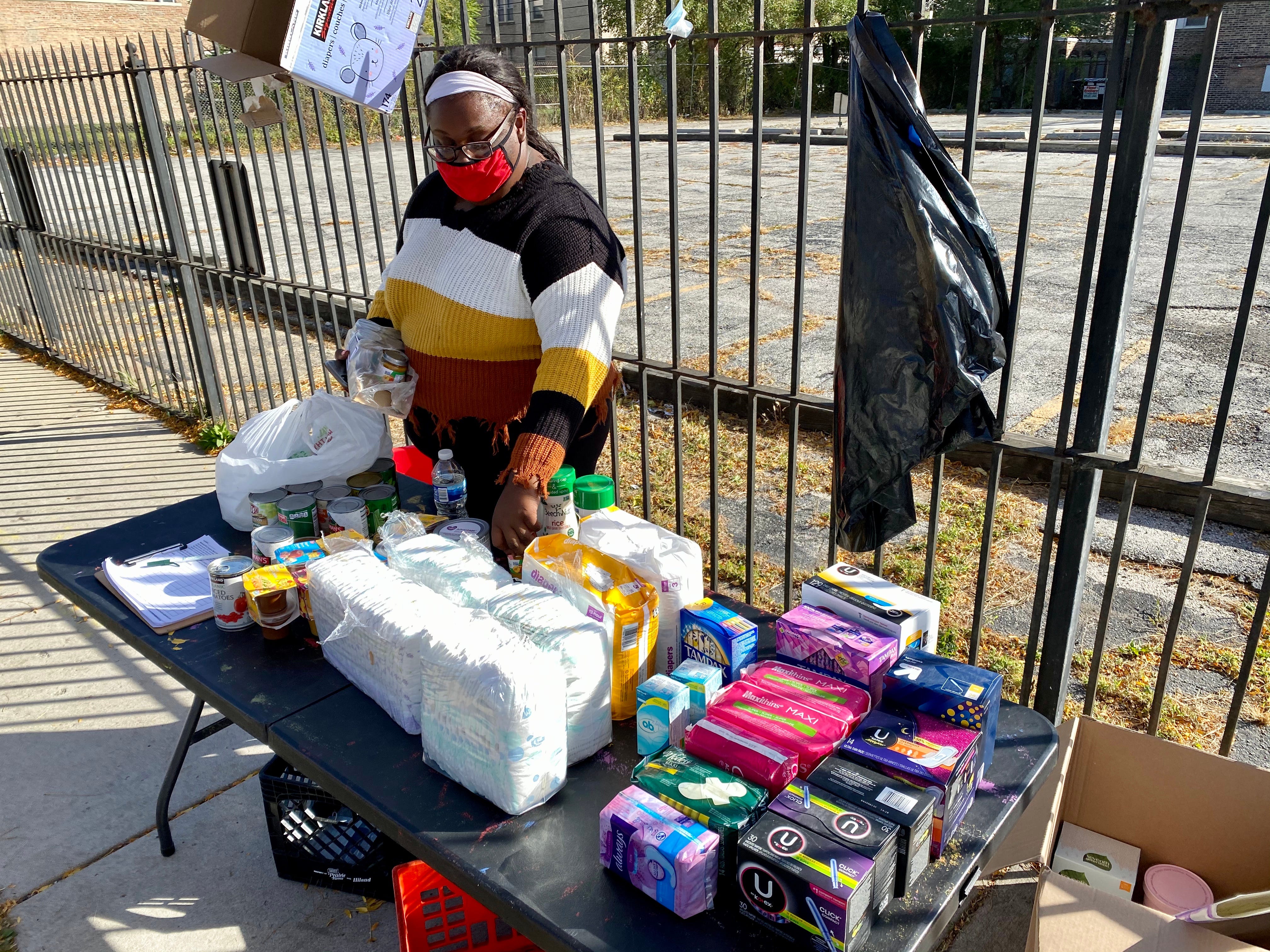 Juanita Tennyson, 23, gives out donated food and household supplies in the South Shore neighborhood on the South Side of Chicago on  Oct. 14., 2020.