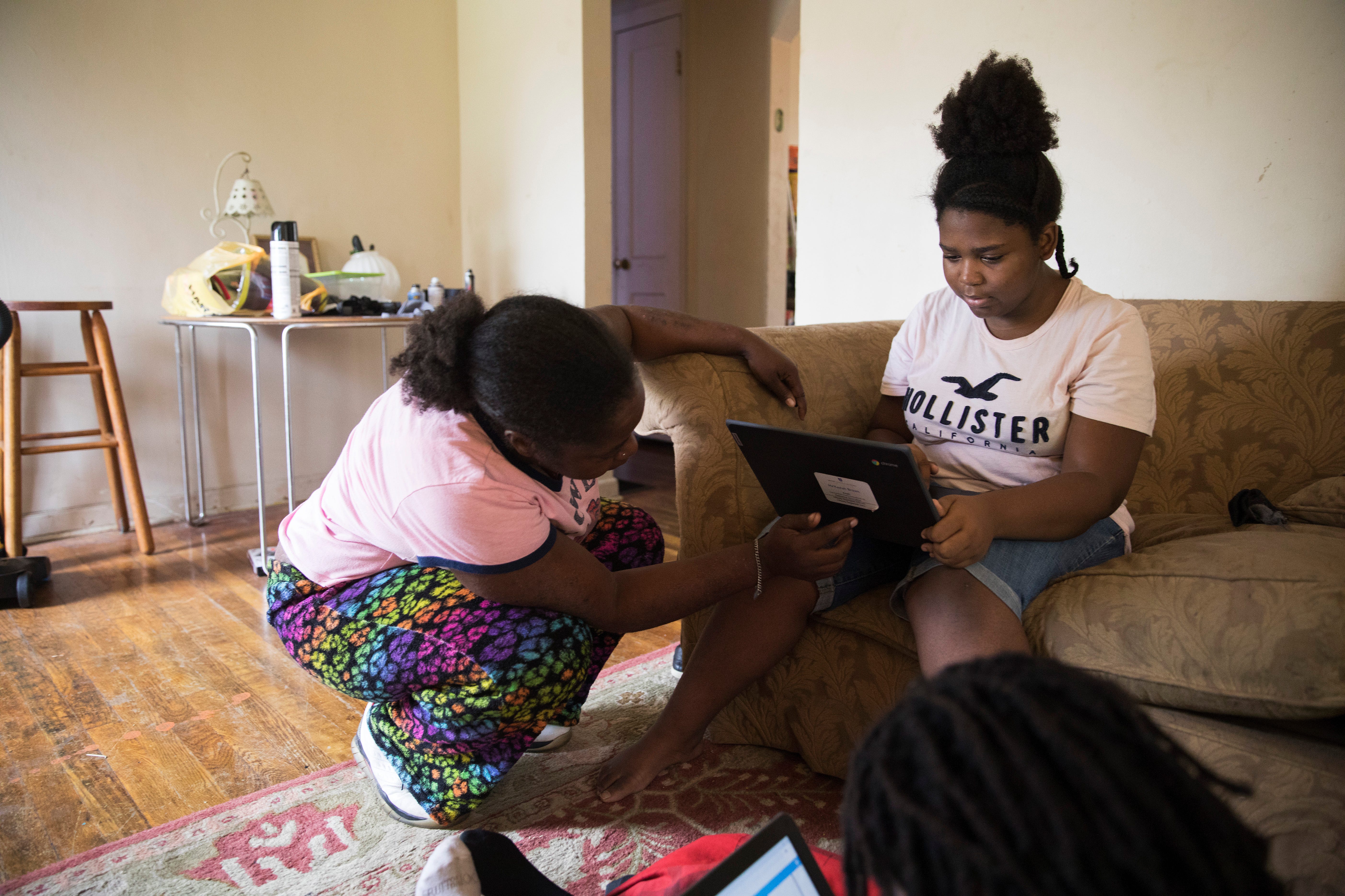 In Columbus, Ohio, Kaneadsha Jones helps her daughter get her computer set up for distance learning.