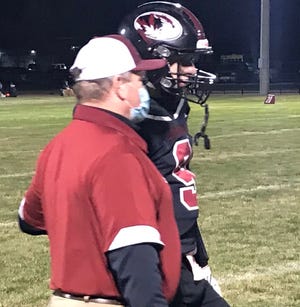 Simms head football coach Jay Fredrickson gives a play to QB Stephen Links during the third quarter of their seeded playoff game against the Cascade Badgers Friday in Simms.