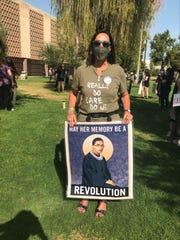 Kathryn Michael holds up her sign honoring late Supreme Court Justice Ruth Bader Ginsburg while at the Arizona Capitol lawn on Oct. 17, 2020.