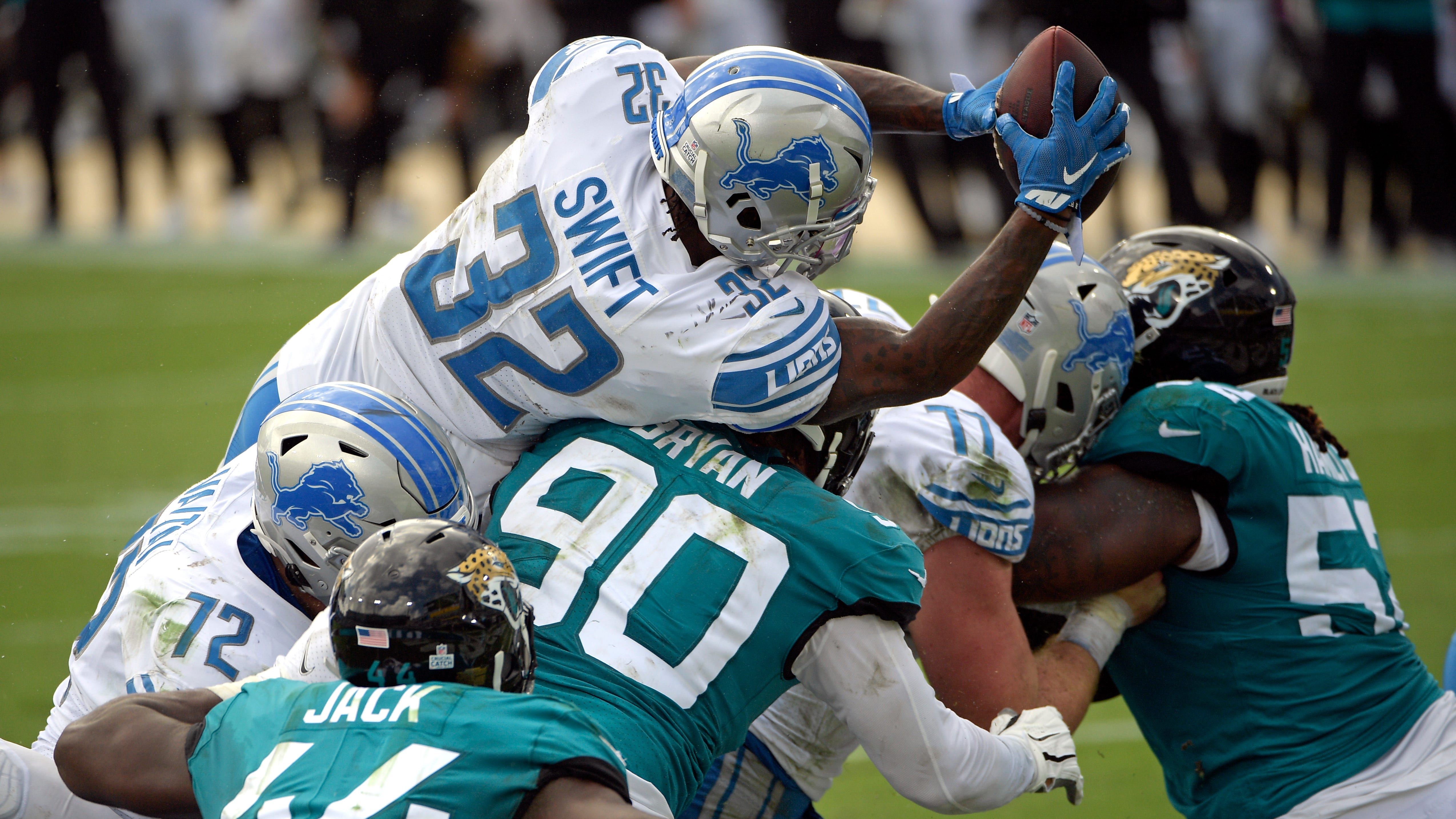 Lions running back D'Andre Swift (32) scores the first of his two touchdowns Sunday against the Jaguars.
