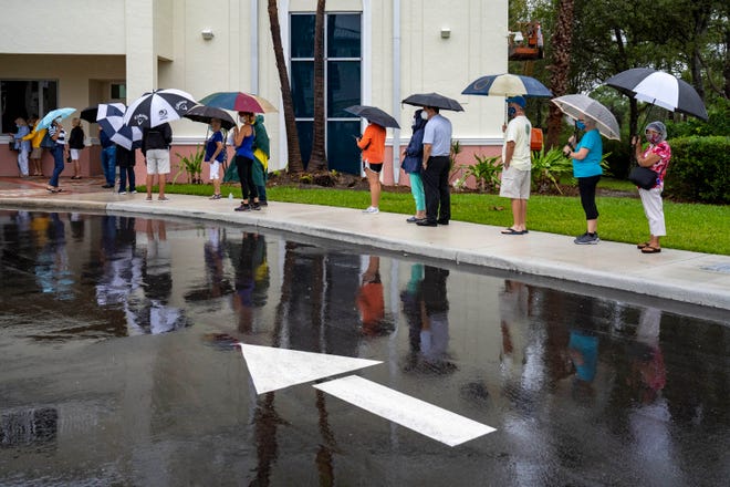 Voters wait in line to cast their ballots on the first day of in person early voting at the Jupiter Community Center in Jupiter, Florida on October 19, 2020. (GREG LOVETT / THE PALM BEACH POST)