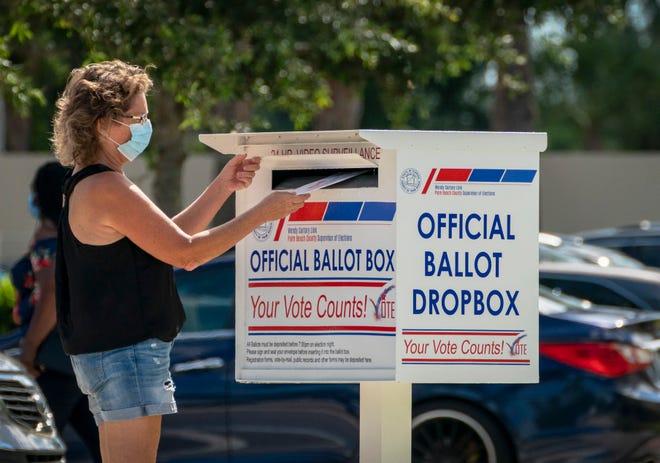 A voter drops off her vote by mail ballot at the Supervisor of Elections office on election day in West Palm Beach, Florida on August 18, 2020.