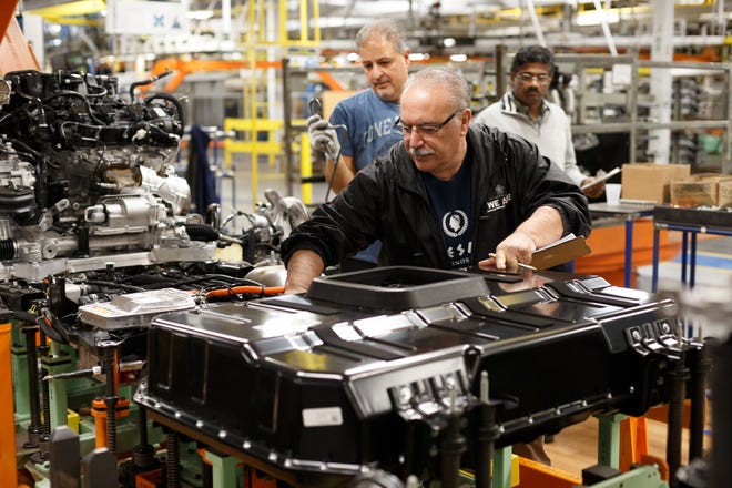 An employee at the Windsor Assembly Plant works on the lithium-ion battery for the Chrysler Pacifica Hybrid minivan. Stellantis plans to retool its plants in Windsor and Brampton.