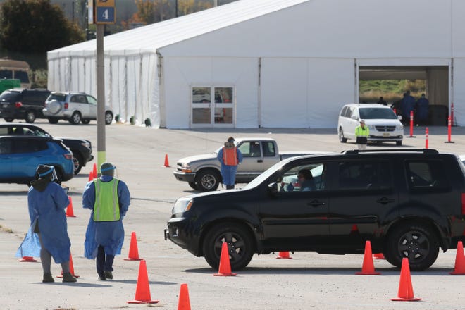 Cars snake through the parking lot on the way to the testing tent at the area's newest COVID-19 testing location at Miller Park on Monday. The site is staffed by the Wisconsin National Guard, Health Department and Milwaukee County EMS team.