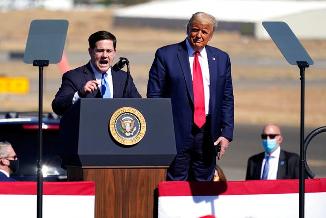 President Donald Trump listens as Arizona Gov. Doug Ducey speaks at a campaign rally at Prescott Regional Airport on Oct. 19, 2020, in Prescott.