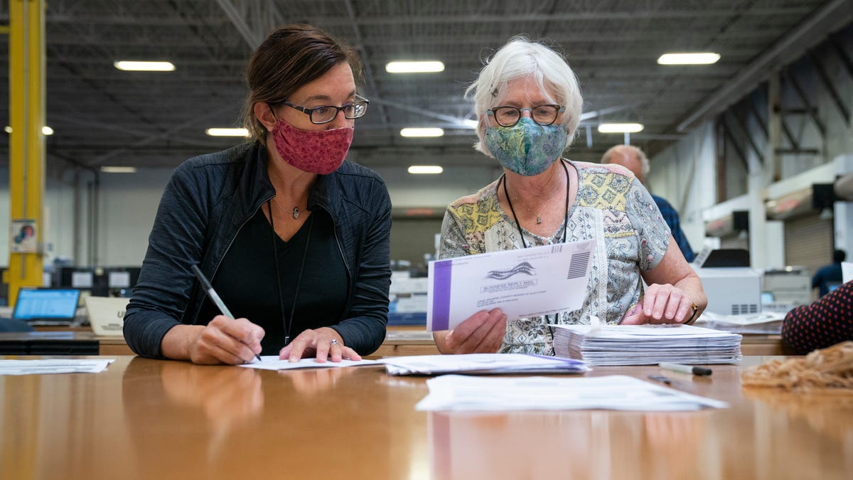 Working in bipartisan pairs, canvassers process mail-in ballots in a warehouse at the Anne Arundel County Board of Elections headquarters on October 7, 2020 in Glen Burnie, Maryland. The ballot canvas for mail-in and absentee ballots began on October 1st in Maryland, the earliest in the country. Every ballot goes through a five step process before being sliced open and tabulated. 
