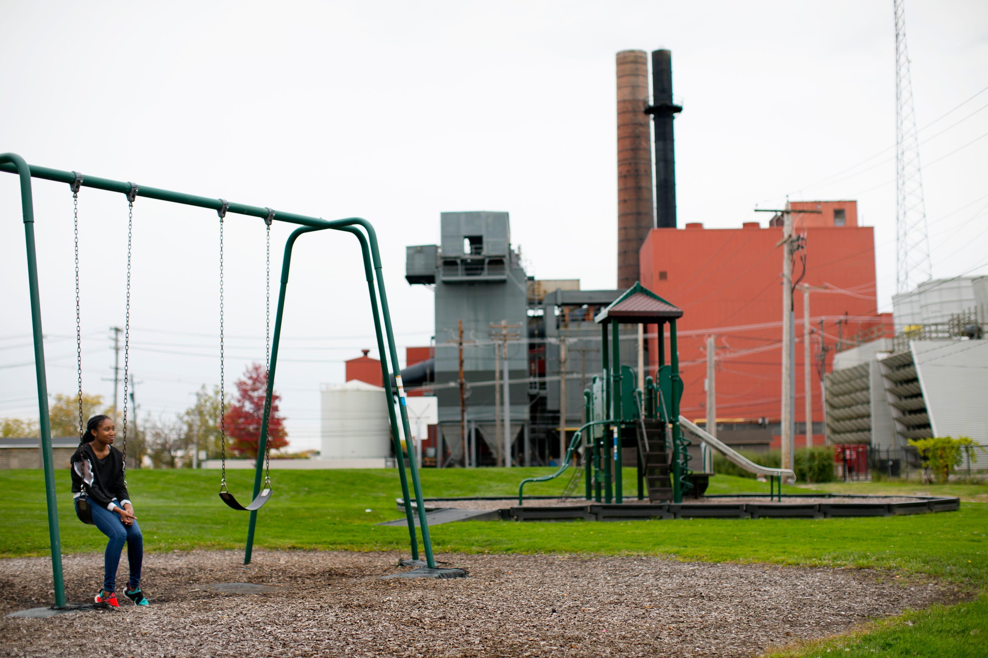 Armani Wells, 13, sits on a swing after school, just across from the city-owned power plant in Painesville, Ohio.