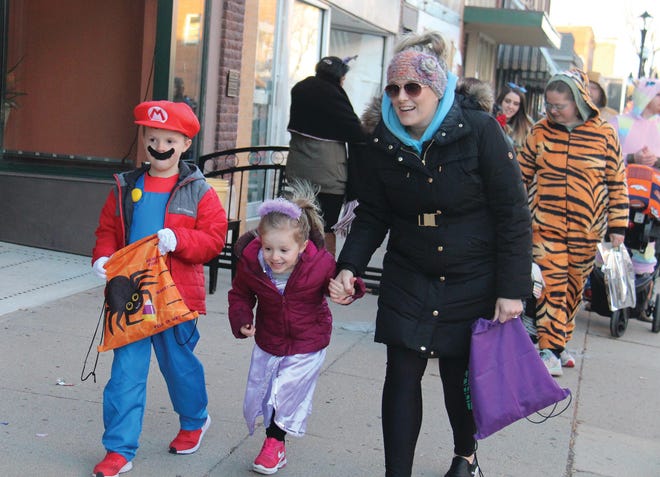 Tenley, middle, is excited about getting more candy while walking with Declan and Kelly Baldwin during the 2019 Spooktacular event.