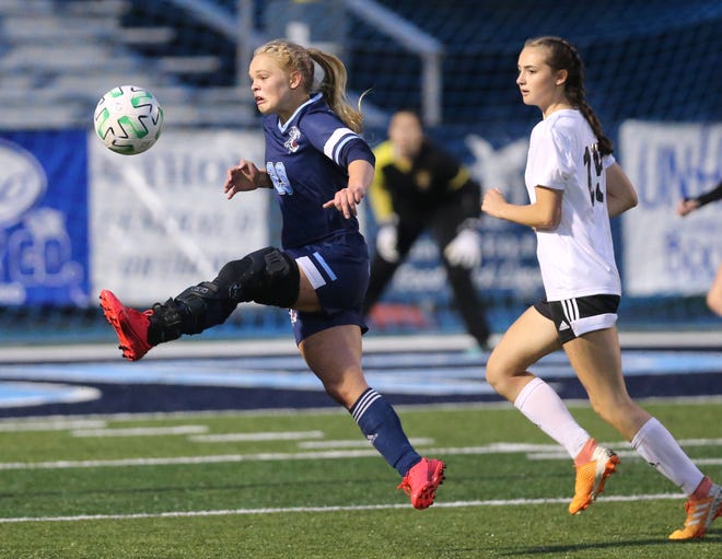 Matti Benson (29) of Louisville takes to the air to advance the ball being defended by Lauren Martin of Cuyahoga Falls during their Division I girls sectional soccer game at Louisville on Monday, Oct. 19, 2020. 