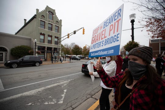 Rachael Raymer, organizer, holds a sign outside of city hall as residents protest the plans to build a gravel pit next to Potter's Bridge Park in Noblesville, Ind. on Monday, October 19, 2020.