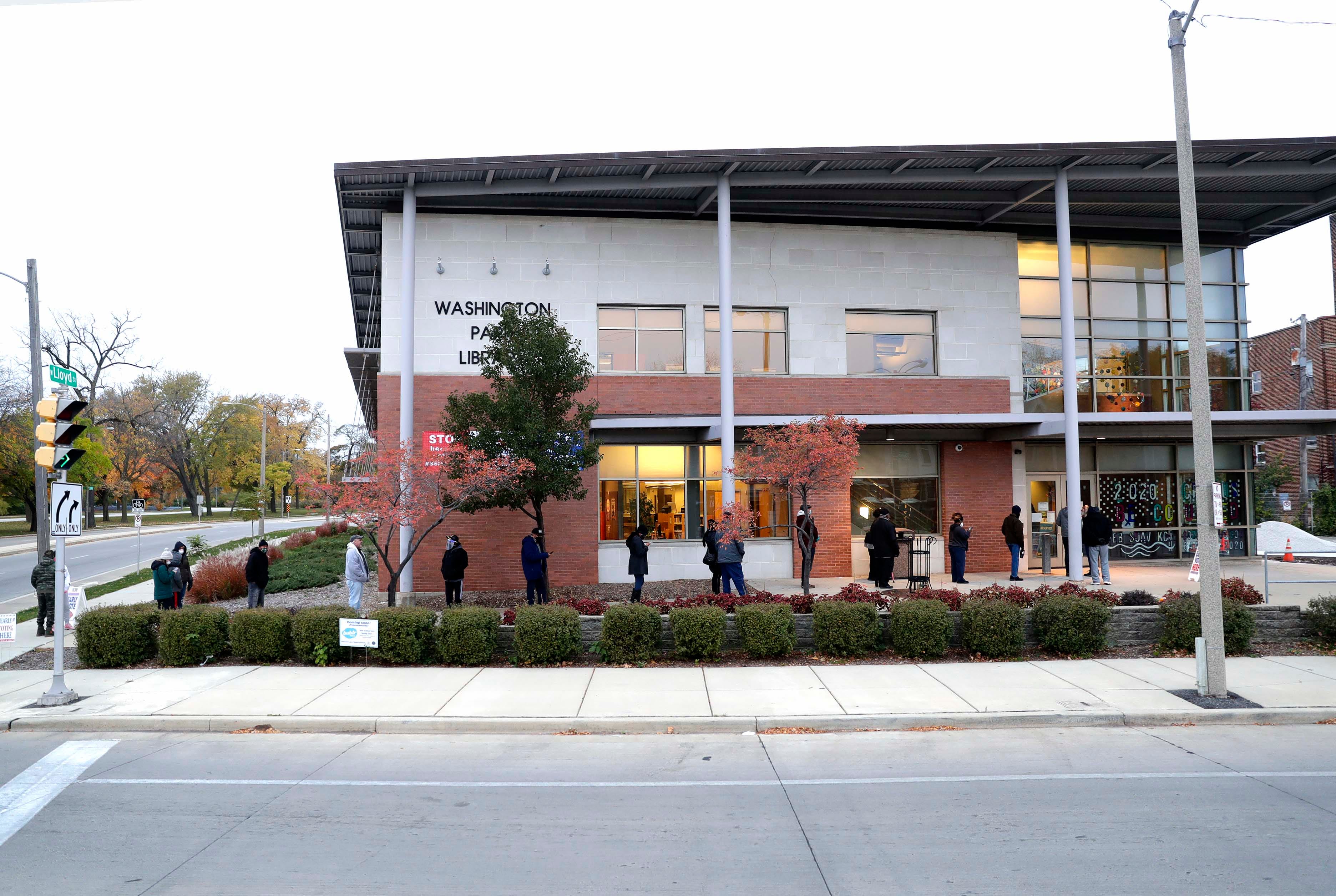 Milwaukee residents are lined up early outside the Washington Park Library to cast their ballots during early voting.