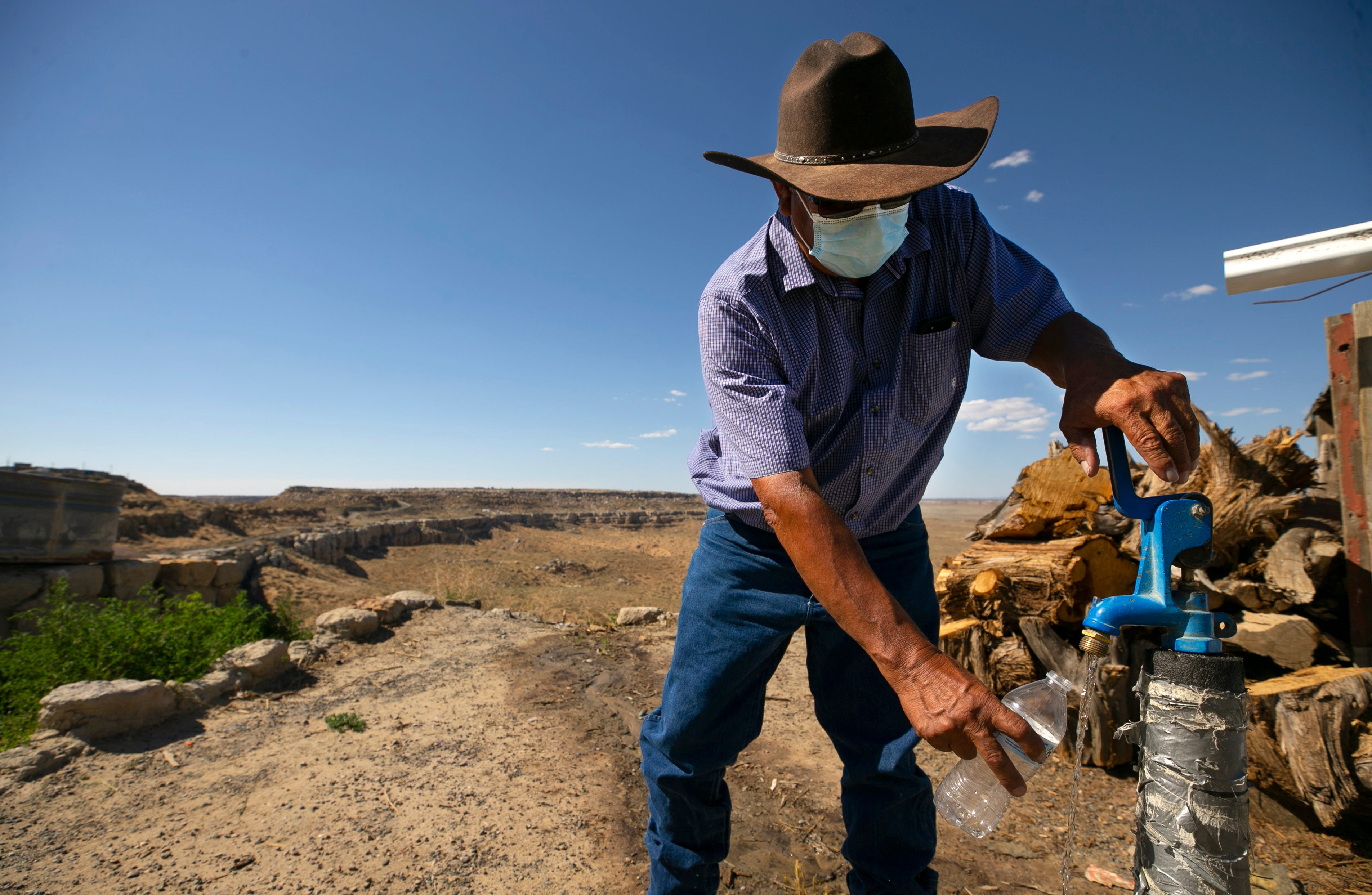 Max Taylor, a Hopi water resource technician, fills a bottle at a communal water source in the village of Mishongnovi on the Hopi Reservation, where many homes do not have running water. This spigot is the closest source for over 100 households in the area.