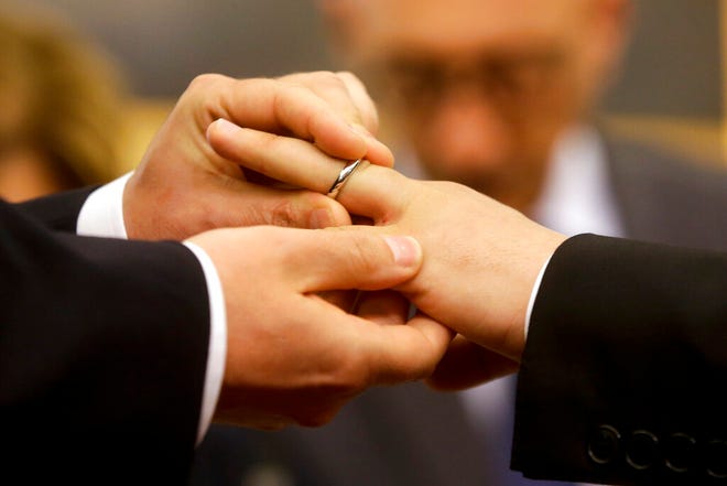 In this May 21, 2015, file photo, Mauro Cioffari, left, puts a wedding ring on his partner Davide Conti's finger as their civil union is being registered by a municipality officer during a ceremony in Rome's Campidoglio Capitol Hill. Pope Francis endorsed same-sex civil unions for the first time as pope while being interviewed for the feature-length documentary "Francesco," which premiered Wednesday, Oct. 21 2020, at the Rome Film Fesregorio Botival.