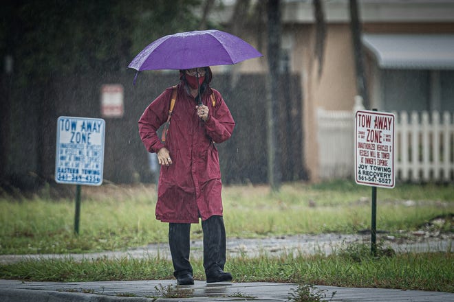 Morning rain falls Wednesday near a PalmTran bus stop on Dixie Highway in Lake Worth Beach.