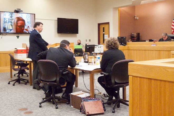 Defendant Alicia Holbrook-Bloink listens from remote onscreen to proceedings in Judge Daniel Bain's courtroom as her attorney Bill McCririe, left, asks questions of a witness Thursday, Oct. 15, 2020 as Assistant Attorney General Daniel Grado and Special Agent Ashley Schwartz with the Attorney General's office listen to the proceedings.