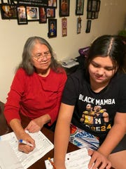 Patricia Whitefoot fills out her ballot with the assistance of her granddaughter, Naomi Hubbard. Whitefoot lives on the Yakima Nation reservation in central Washington state. A former tribal education official, she stays mostly inside because of the pandemic but uses her phone and computer to help other Native Americans register to vote.
