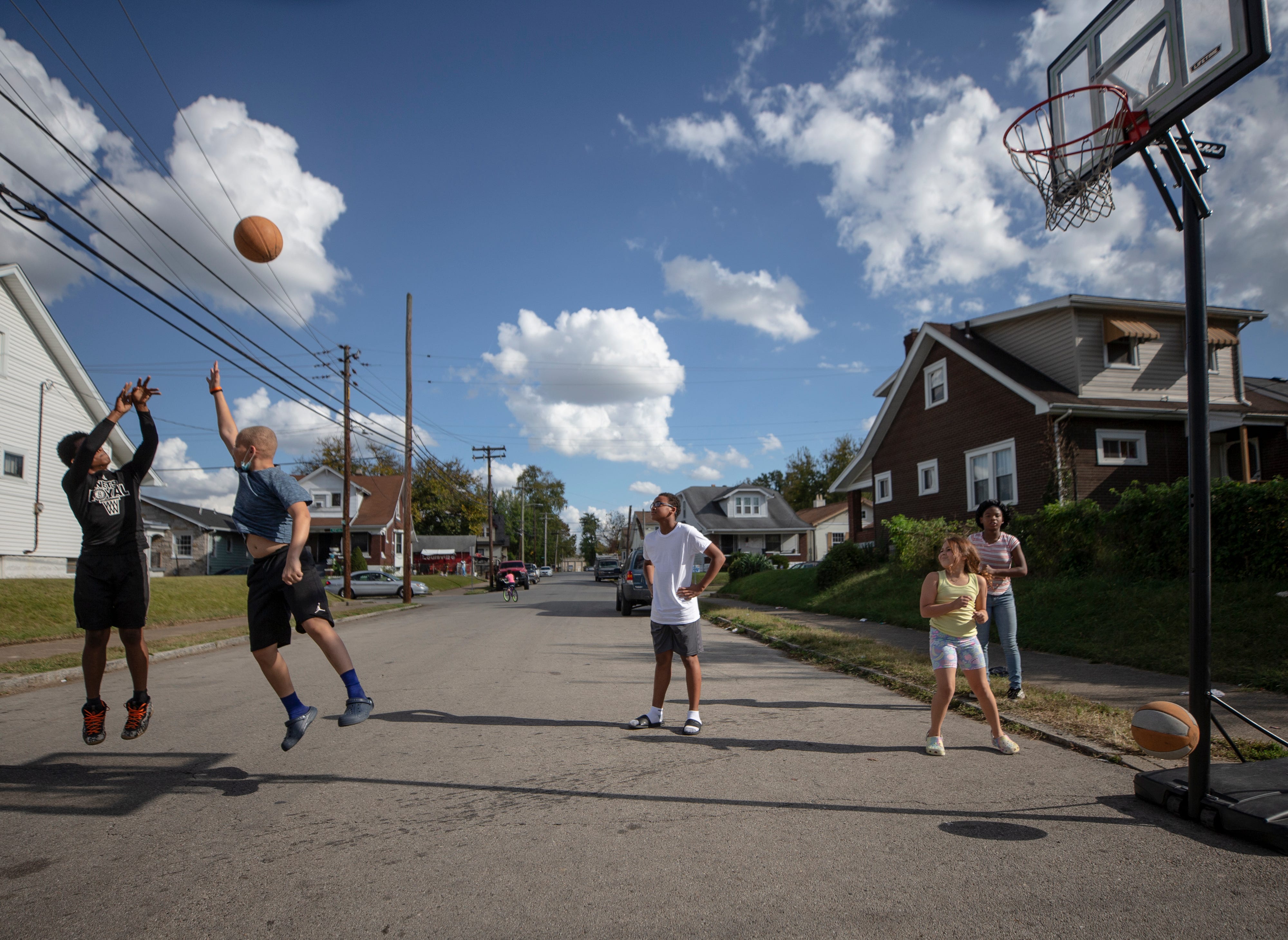 Chris Miller, 13, right, gets off a shot against Kentrelle Bell, 13, while playing basketball on Herman Street in Louisville's Shawnee neighborhood on Oct. 22, 2020.