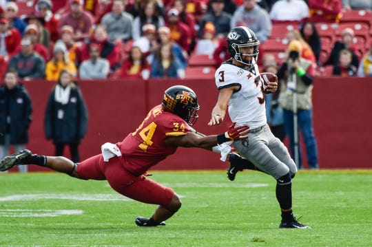 Oklahoma State quarterback Spencer Sanders tries to avoid the tackle of Iowa State linebacker O'Rien Vance during their 2019 game at Jack Trice Stadium.