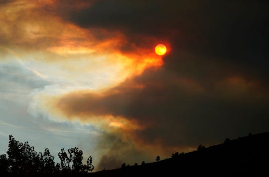 Smoke obscures the sun as fire approaches a ridge along Highway 36 as several wildfires burn in the state Wednesday, Oct. 21.