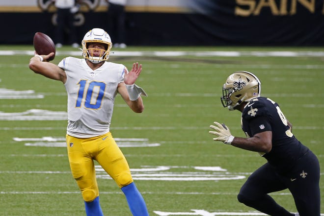 Los Angeles Chargers quarterback Justin Herbert (10) passes under pressure from New Orleans Saints defensive end Cameron Jordan (94) in the first half of an NFL football game in New Orleans. Butch Dill/(Associated Press