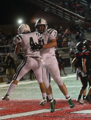 Aurora’s Evan McVay and Joey Arnold celebrate a touchdown in the first half of the Division III playoff game at New Philadelphia Friday.