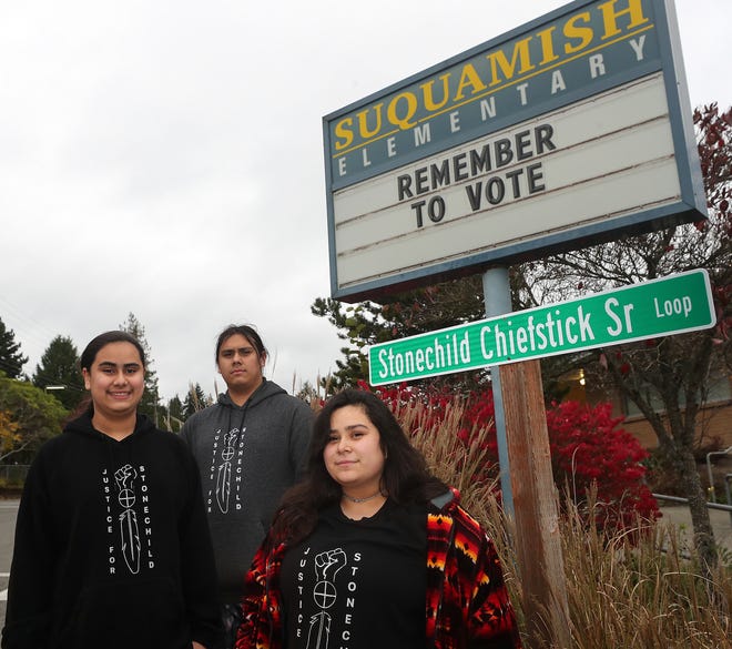 Stonechild Chiefstick's children, left to right, Kane, Stonechild Jr. and Alana with a street sign honoring their late father at Suquamish Elementary School.