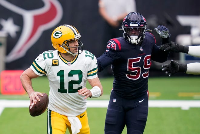 Green Bay Packers quarterback Aaron Rodgers (12) scrambles away from Houston Texans linebacker Whitney Mercilus (59) during the first half of an NFL football game Sunday, Oct. 25, 2020, in Houston.