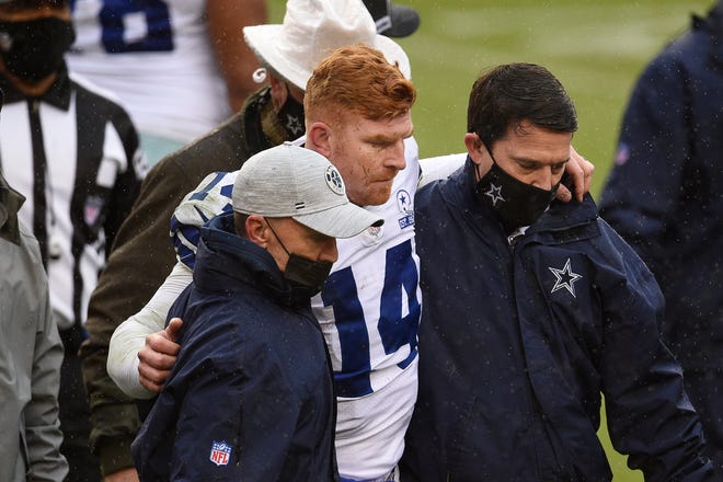 Quarterback Andy Dalton #14 of the Dallas Cowboys is helped off the field after being hit and injured by Jon Bostic #53 (not pictured) of the Washington Football Team in the third quarter of the game at FedExField on October 25, 2020 in Landover, Maryland.