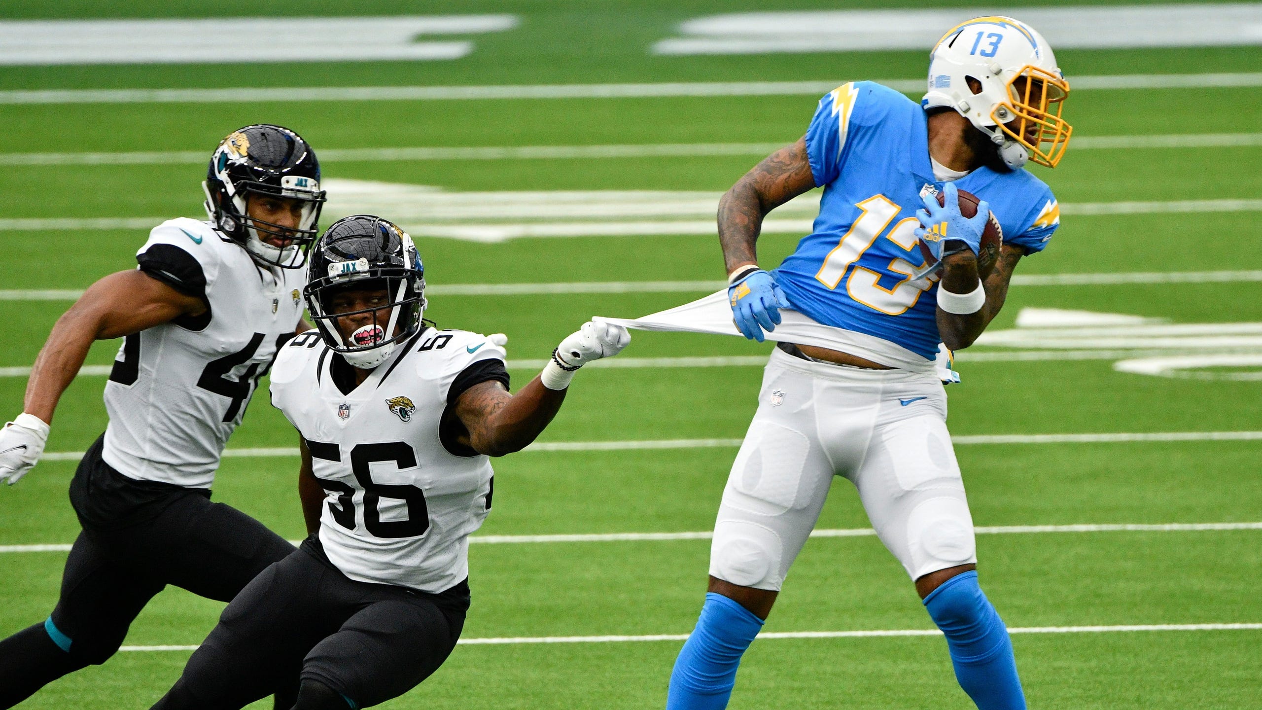 Jacksonville Jaguars linebacker Quincy Williams (56) gets a handful of jersey as Los Angeles Chargers wide receiver Keenan Allen (13) breaks free during the first quarter at SoFi Stadium. [Robert Hanashiro-USA TODAY Sports]
