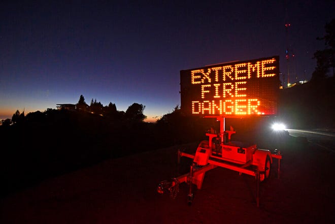 A roadside sign warns motorists of extreme fire danger on Grizzly Peak Boulevard, in Oakland, Calif., Sunday, Oct. 25, 2020. Due to high winds and dry conditions PG&E will turn off the power to over 361,000 customers in 36 counties to protect them from possible wildfires caused by downed power lines. The National Weather Service predicts offshore winds from the north peaking at higher elevations up to 70 mph.
