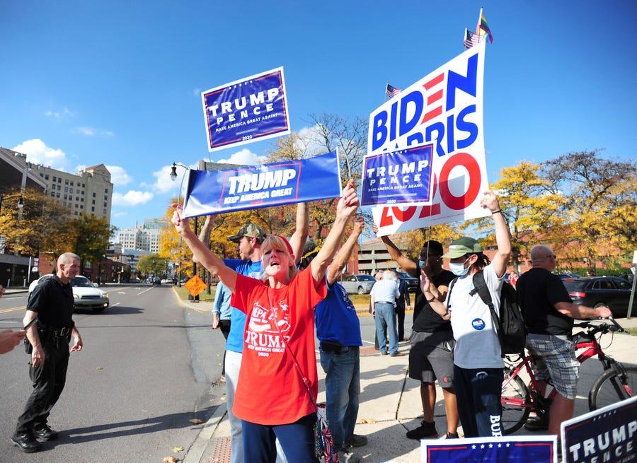 President Donald Trump supporters and Democratic presidential candidate Joe Biden supporters square off in front of Penn Place office building in Wilkes-Barre, Pa., Thursday, Oct. 22, 2020. The Luzerne County Election Bureau is located inside Penn Place where early walk-in voting has started.