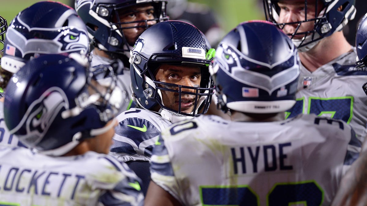Seattle Seahawks quarterback Russell Wilson (3) huddles with teammates against the Arizona Cardinals during the first half at State Farm Stadium.