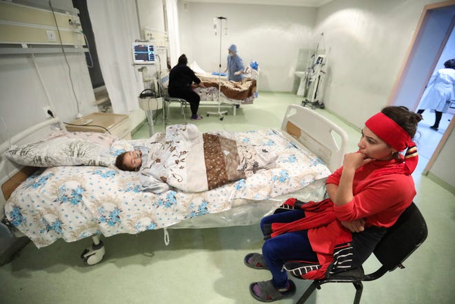 A woman sits next to her wounded child during shelling by Armenian forces daughter at a hospital in Barda, Azerbaijan, on Tuesday. Fighting over Nagorno-Karabakh is raging, unimpeded by a U.S.-brokered cease-fire, while Armenia and Azerbaijan are trading blame for the deal's quick unraveling.