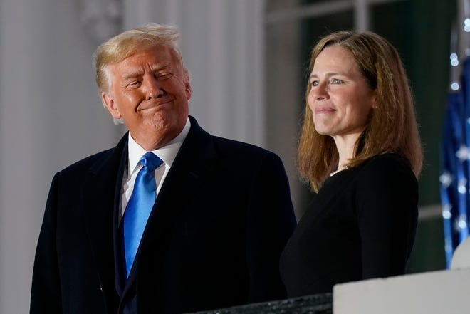 President Donald Trump and Amy Coney Barrett stand on the Blue Room Balcony after Supreme Court Justice Clarence Thomas administered the Constitutional Oath to her on the South Lawn of the White House White House in Washington on Monday.