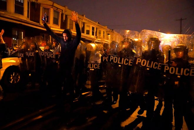 Sharif Proctor lifts his hands up in front of the police line during a protest in response to the police shooting of Walter Wallace Jr., Monday, Oct. 26, 2020, in Philadelphia. Police officers fatally shot the 27-year-old Black man during a confrontation Monday afternoon in West Philadelphia that quickly raised tensions in the neighborhood. (Jessica Griffin/The Philadelphia Inquirer via AP)