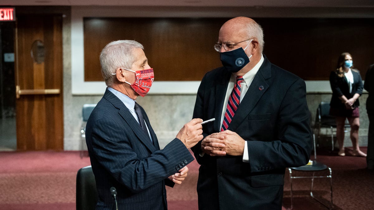 Director of the National Institute of Allergy and Infectious Diseases Dr. Anthony Fauci speaks with Dr. Robert Redfield, director of the Centers for Disease Control and Prevention during a Senate Health, Education, Labor and Pensions Committee hearing on Capitol Hill in Washington, Tuesday, June 30, 2020. 