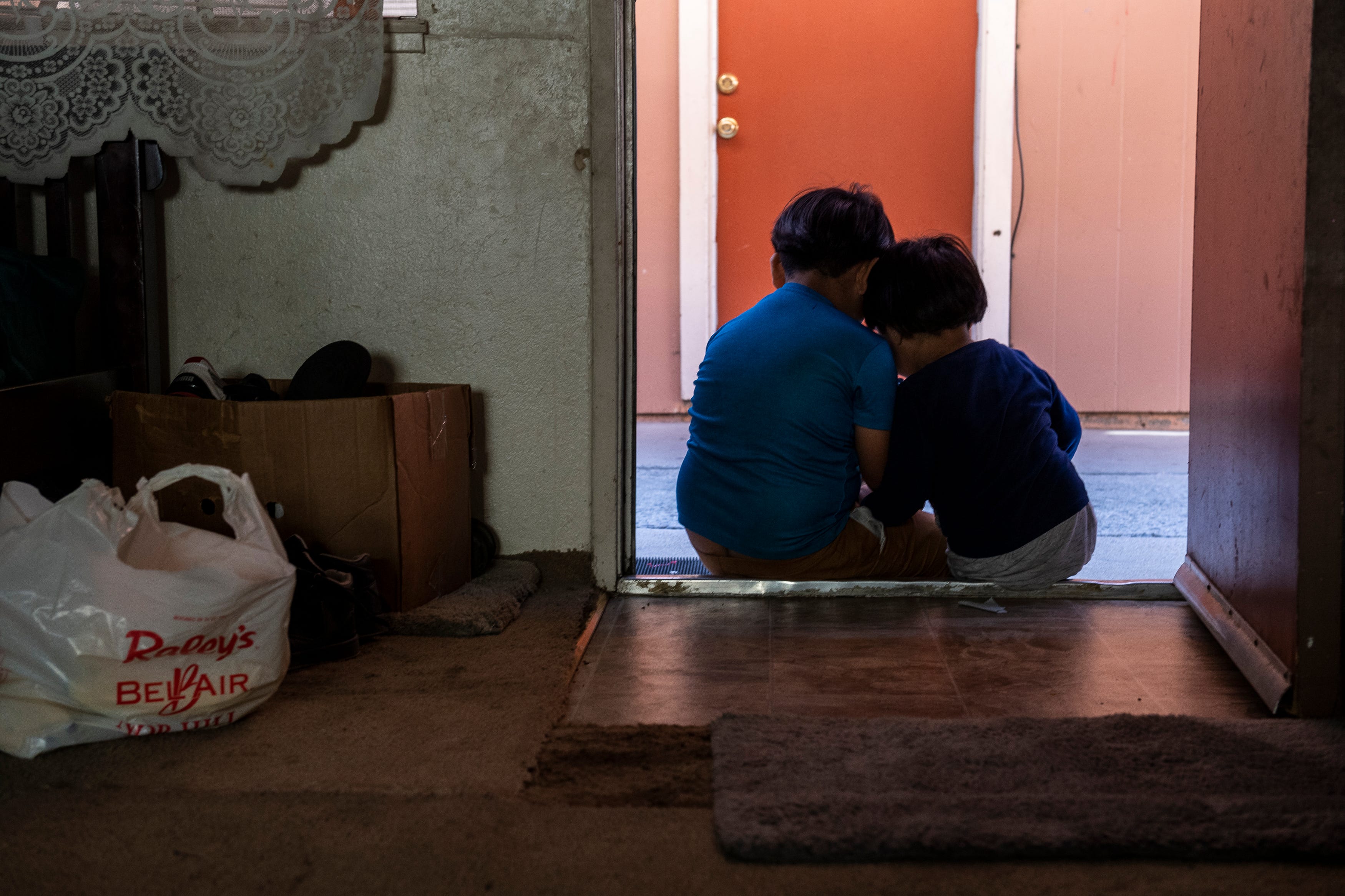 Hugo Salvador, 7, left, sits on a doorstep with his younger brother Jesus Salvador, 3, as they rest their heads on one another in Salinas, Calif., on Saturday, Sept. 26, 2020. 