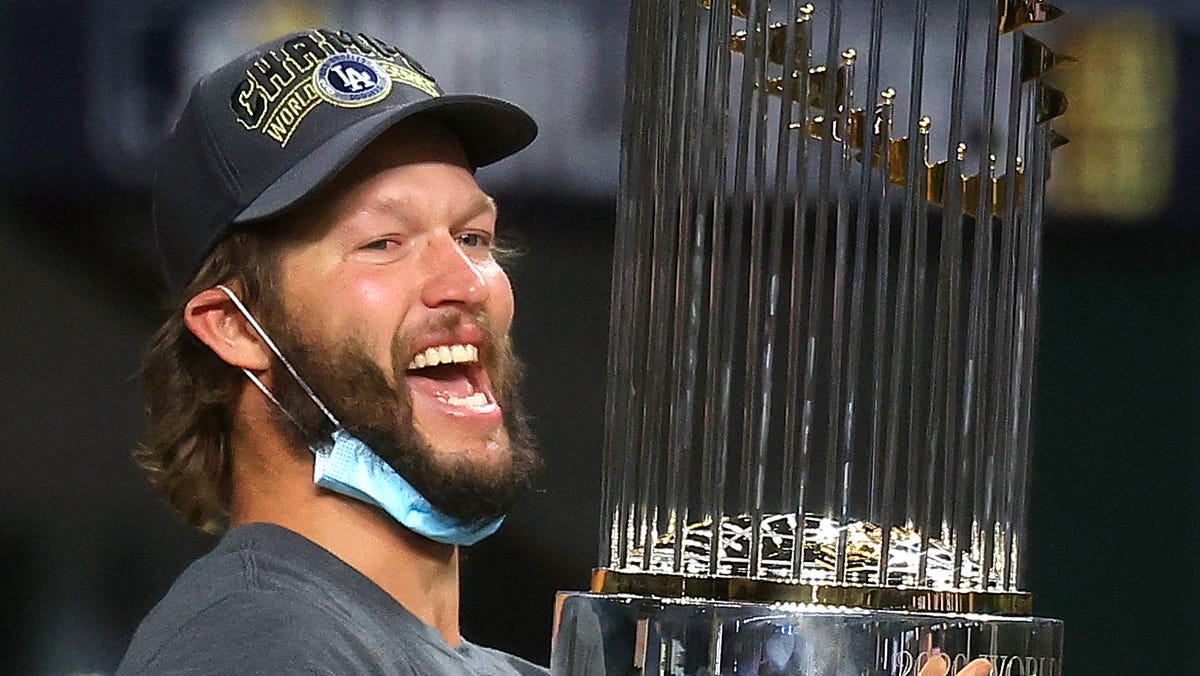 Clayton Kershaw #22 of the Los Angeles Dodgers celebrates with the Commissioners Trophy after defeating the Tampa Bay Rays 3-1 in Game Six to win the 2020 MLB World Series at Globe Life Field on October 27, 2020 in Arlington, Texas.