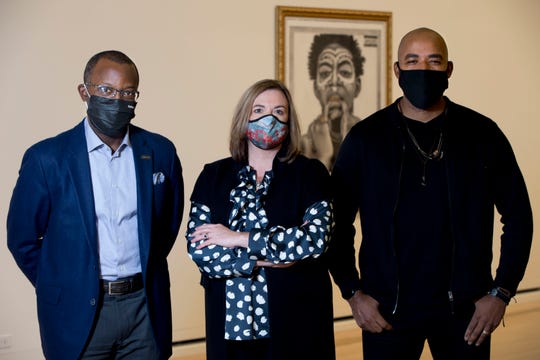 Mel Gravely, CEO of TriVersity Construction and co-chair of Flow's Board of Advisors, left, stands with Alecia Kintner, Arts Wave president and CEO, and Gee Horton, the artist of "If I Ruled the World... Imagine That!", seen in the background, stand together inside the Cincinnati Art Museum on Thursday, Oct. 29, 2020, in Cincinnati, Ohio. Gravely recently received the Deloitte Cincinnati USA 100's Carl H. Lindner Award. He is co-chairing Flow, a program that features quarterly performances by renowned Black artists and ensembles from across the country, working in various disciplines including Gee Horton's work. Flow, a part of ArtsWave, is designed to showcase professional, evocative Black artists.