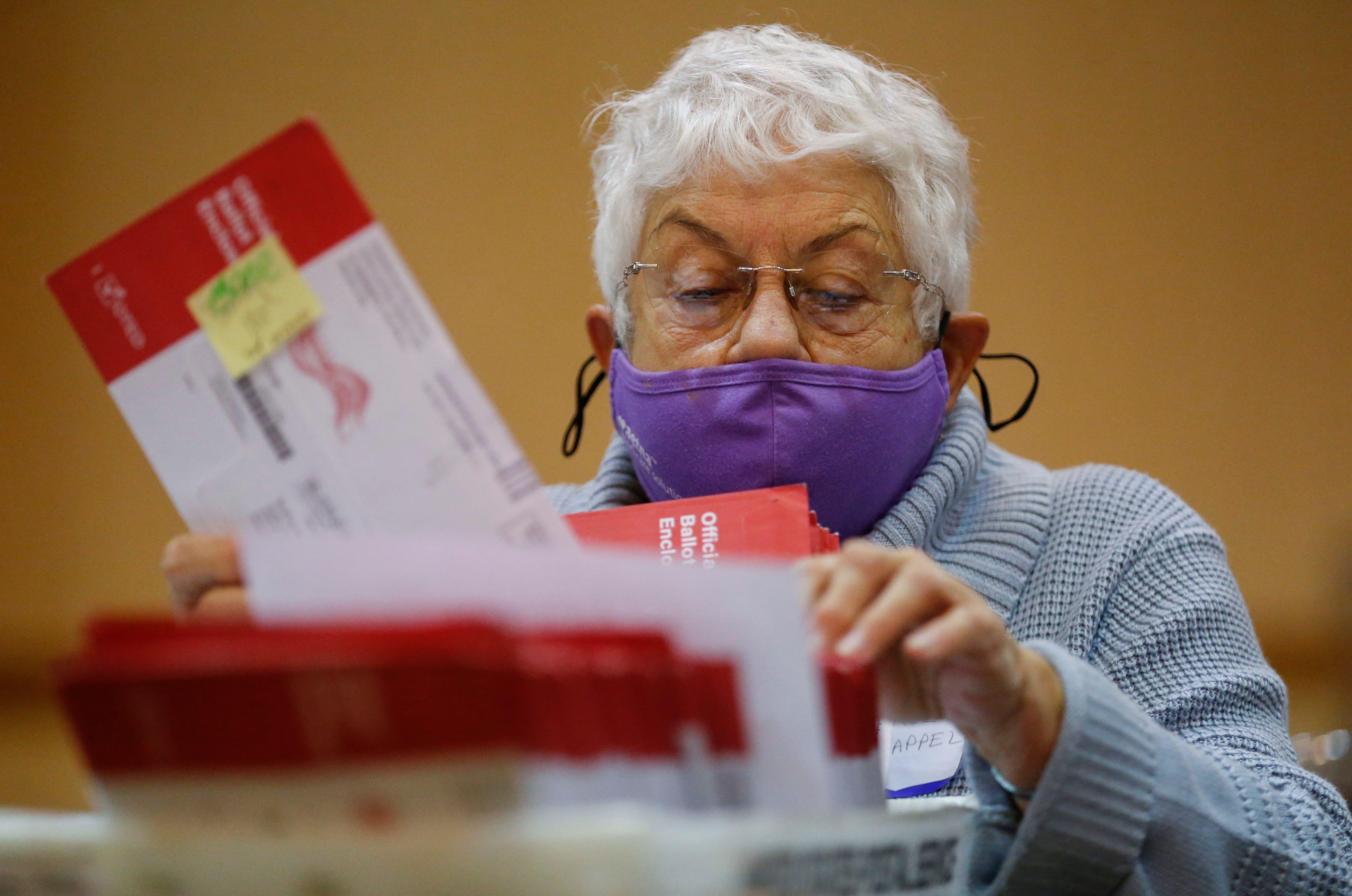 Carol Chappell sorts through absentee ballots at the University Plaza Convention Center on Thursday, Oct. 29, 2020.